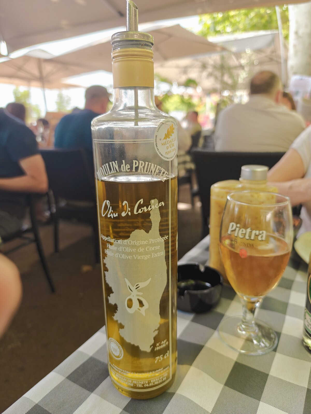 Des touristes consultent leur plan sur smartphone, attablés à la terrasse d’un café corse.